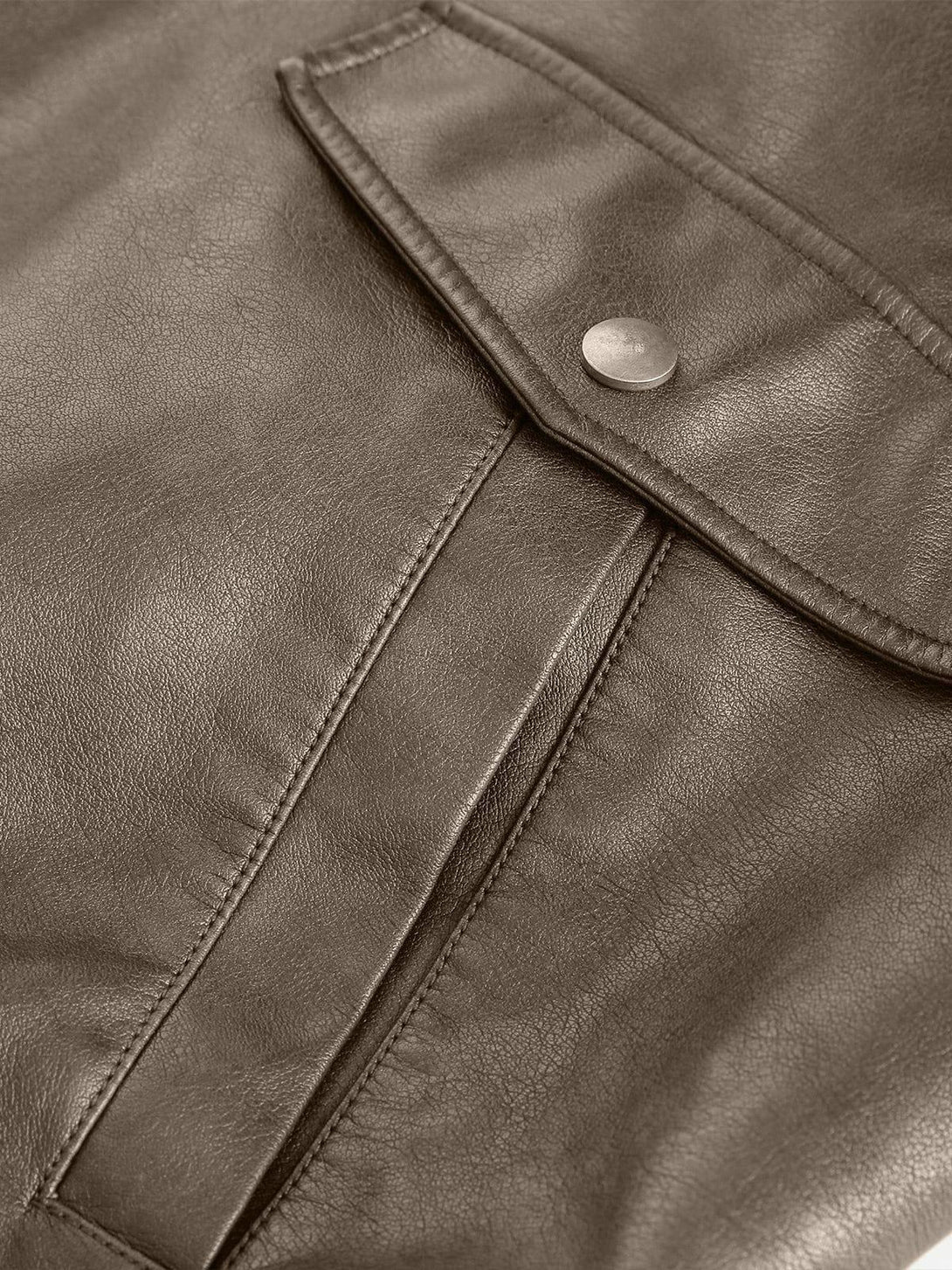 Intricate look at the TALISHKO faux leather jacket's texture and stitching details.