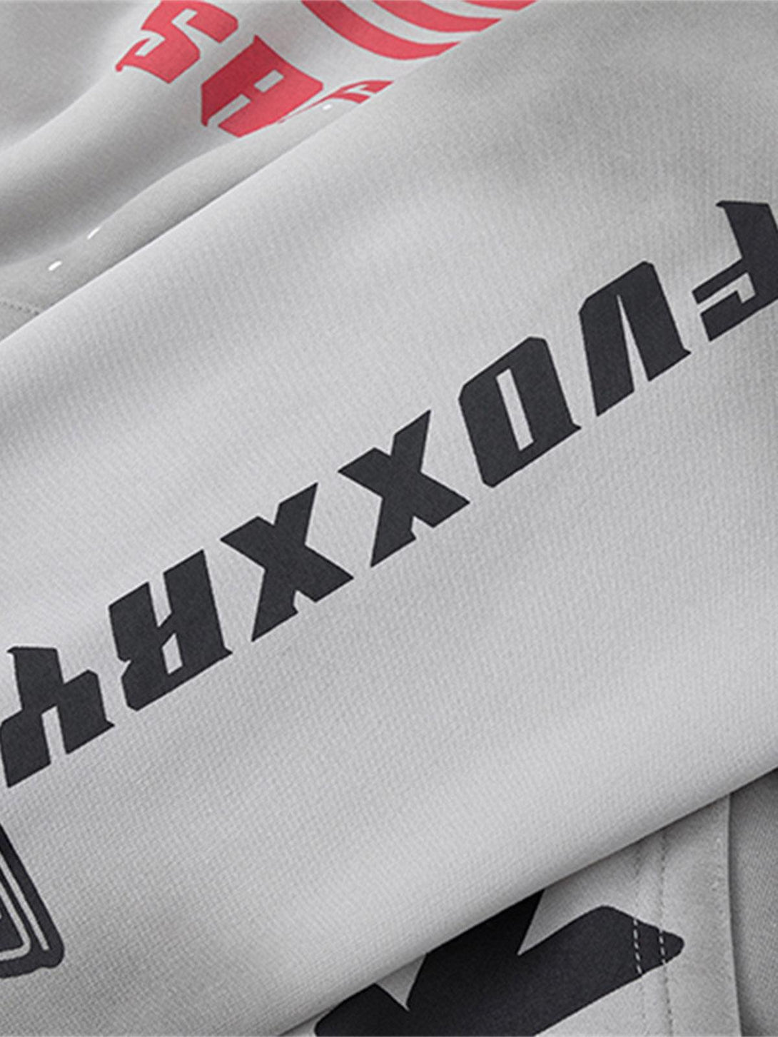 Close-up of a TALISHKO racing hoodie showcasing bold graphics on washed gray fabric.