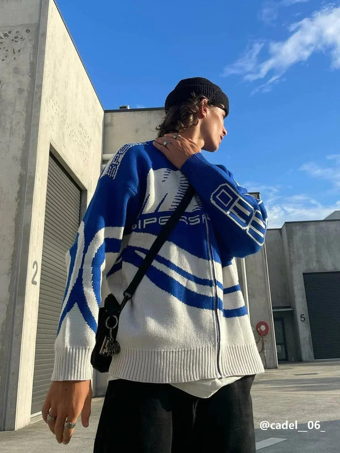 Model in TALISHKO "SPEED" print cardigan, styled with a beanie for a casual outdoor look.