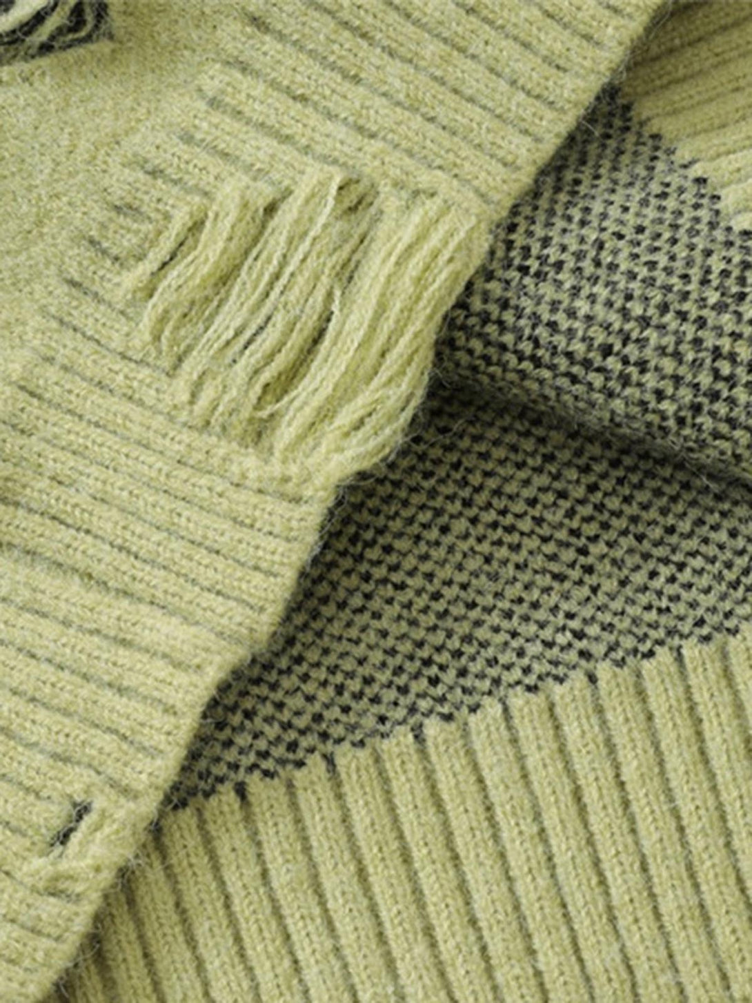 Intricate look at TALISHKO's sweater, showcasing ribbed texture and distressed detail.