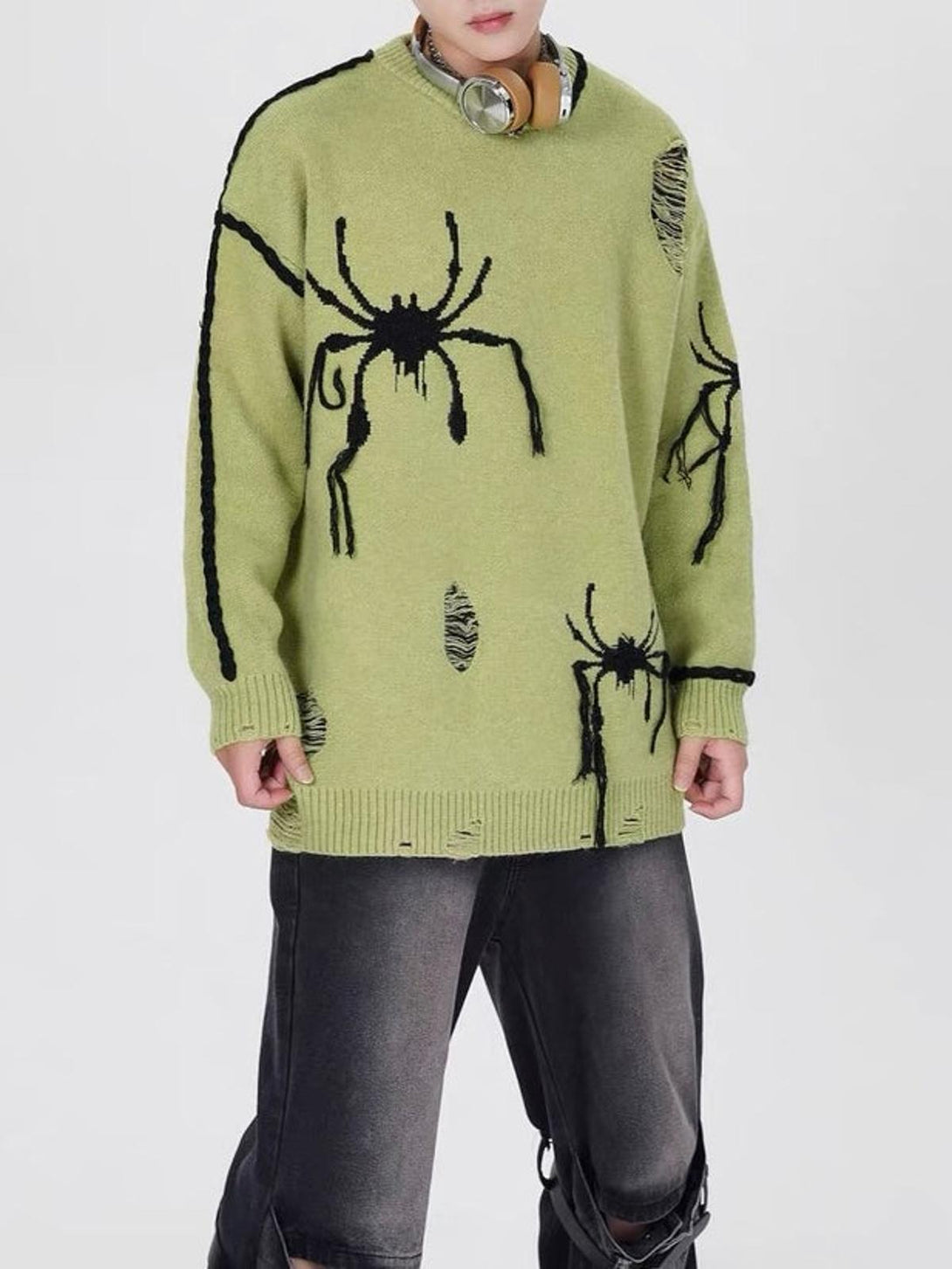 Model showcasing a green oversized sweater with spider design and distressed style by TALISHKO.