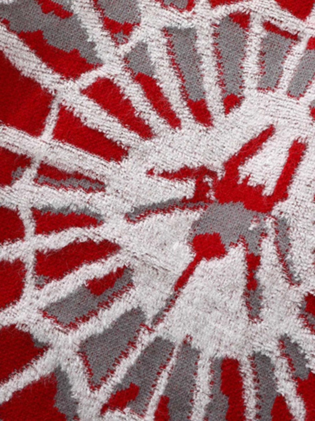 Zoomed-in texture of TALISHKO's knit sweater, showcasing an intricate spider web pattern.