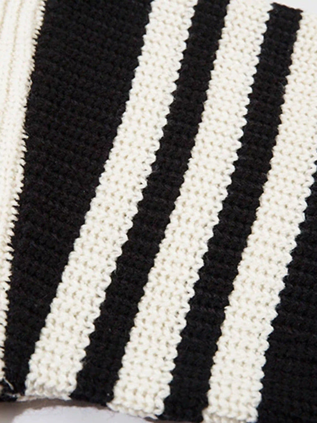 Texture and pattern showcased on TALISHKO's black and white striped cardigan detail.