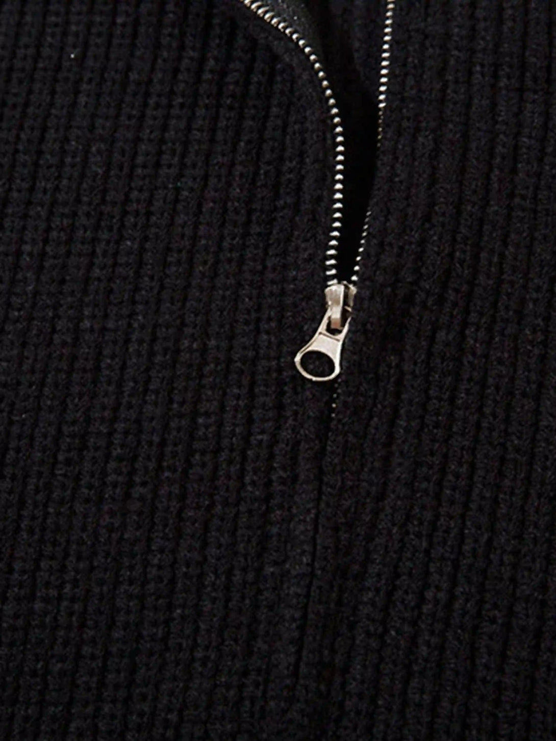 Detailed fabric and stitching on TALISHKO's black zip-up cardigan, highlighting texture.