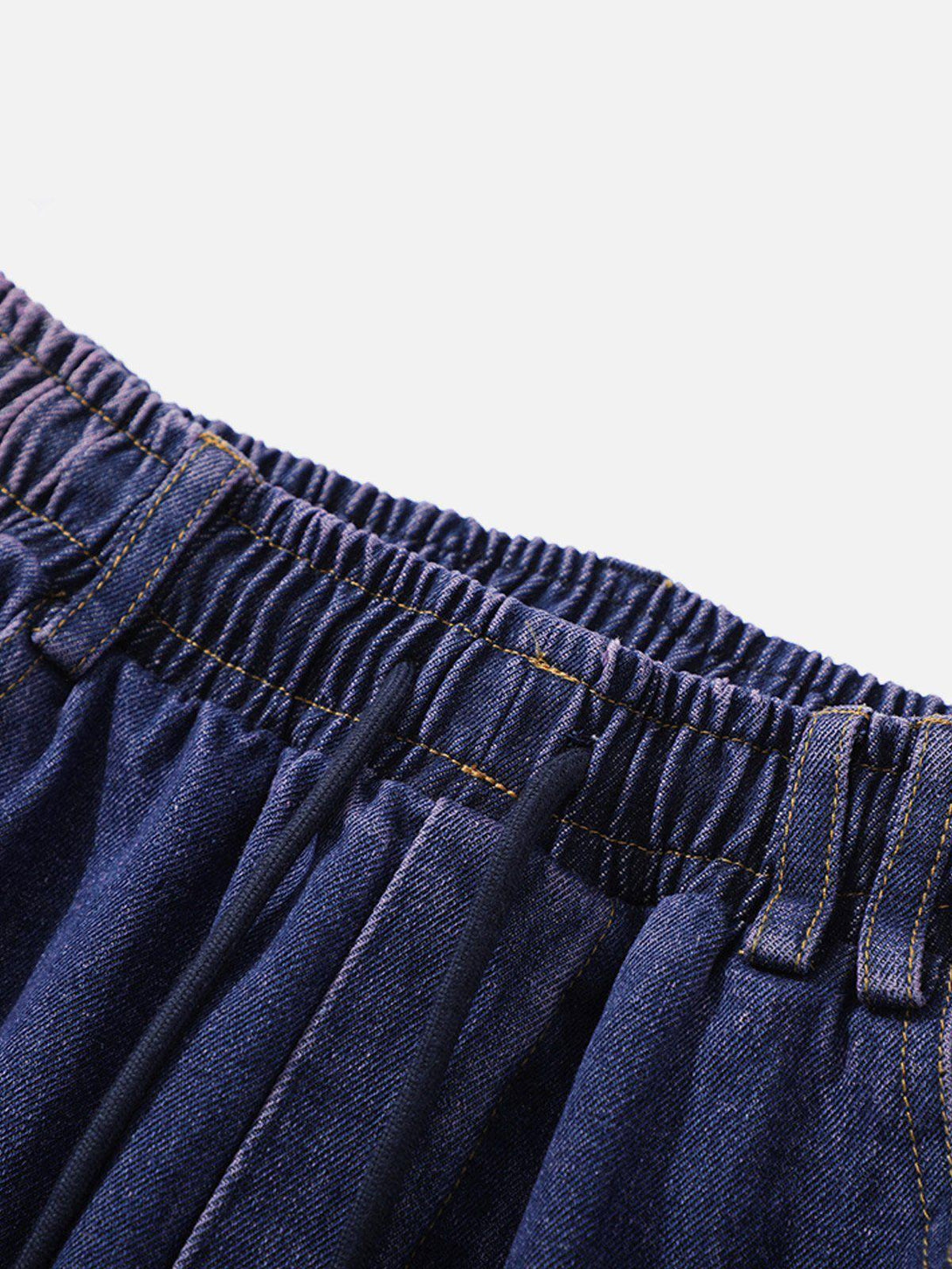 Intricate look at the elastic waistband of TALISHKO's splash ink washed loose jeans.