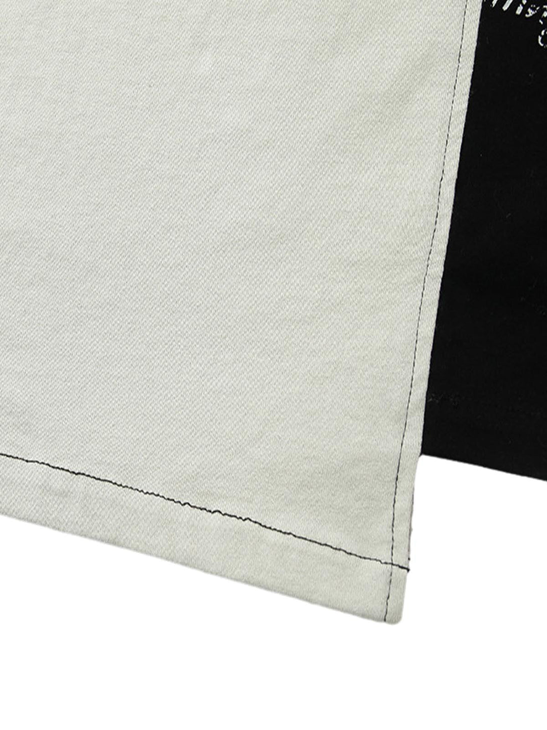 Detailed fabric and stitching of TALISHKO's spliced deconstruction print T-shirt hemline.