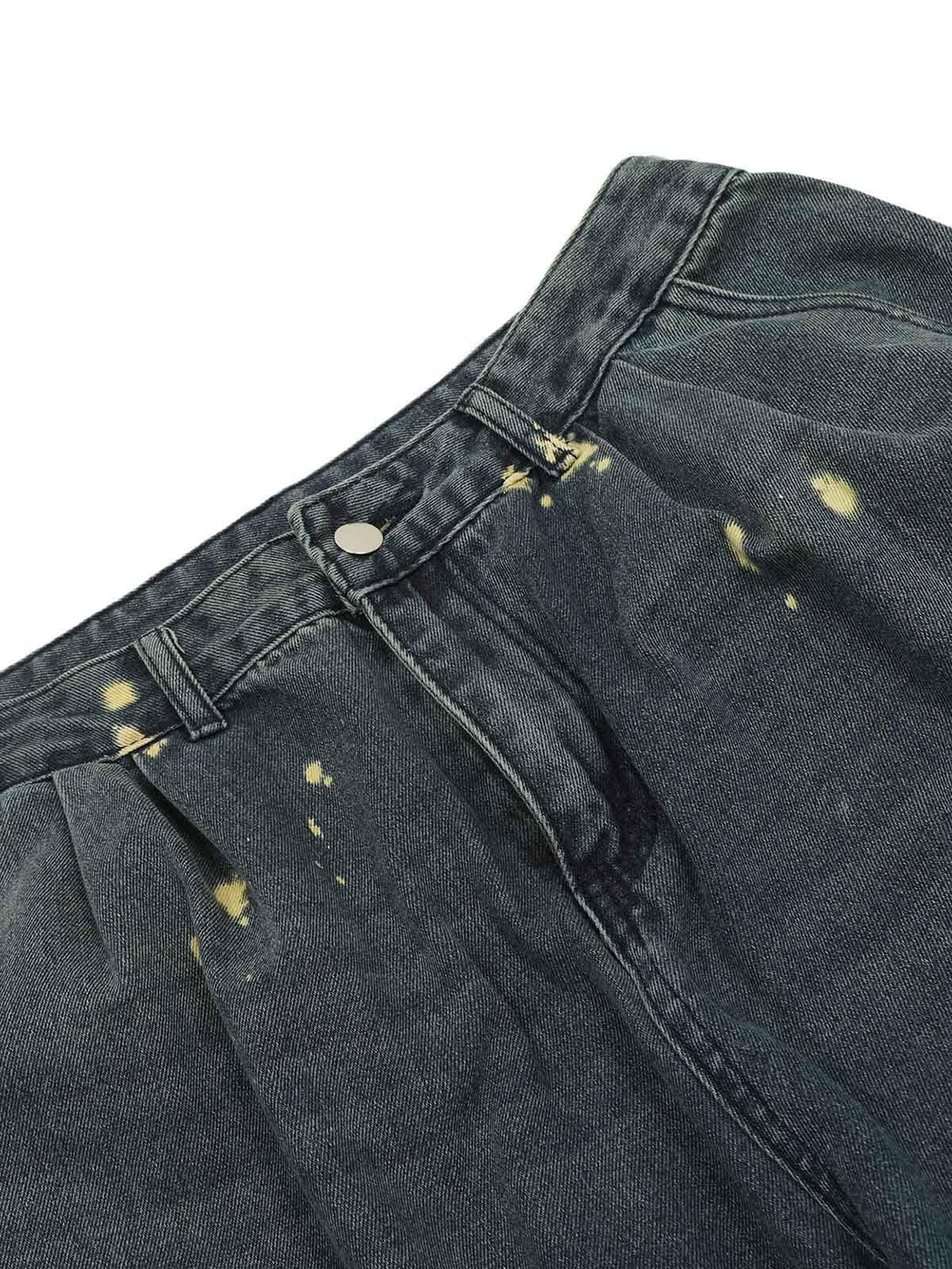 Zoomed-in texture of spray-painted cargo jeans by TALISHKO, highlighting pleated details.