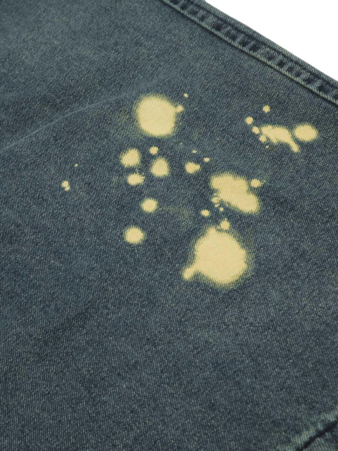 Focusing on the spray-painted pattern on TALISHKO cargo jeans, highlighting unique texture.