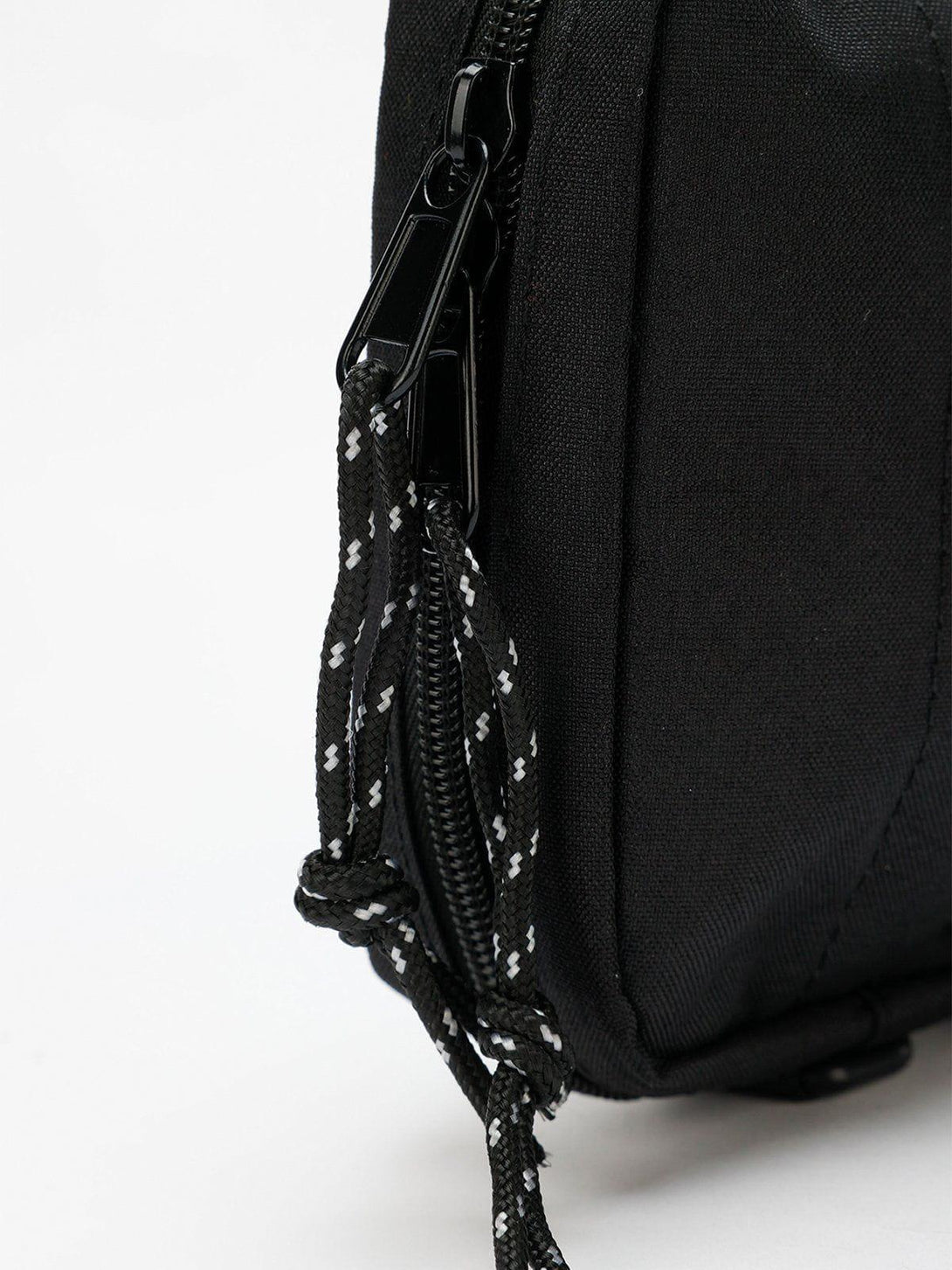"Close-up of TALISHKO's black square crossbody bag, highlighting zipper and rope details."