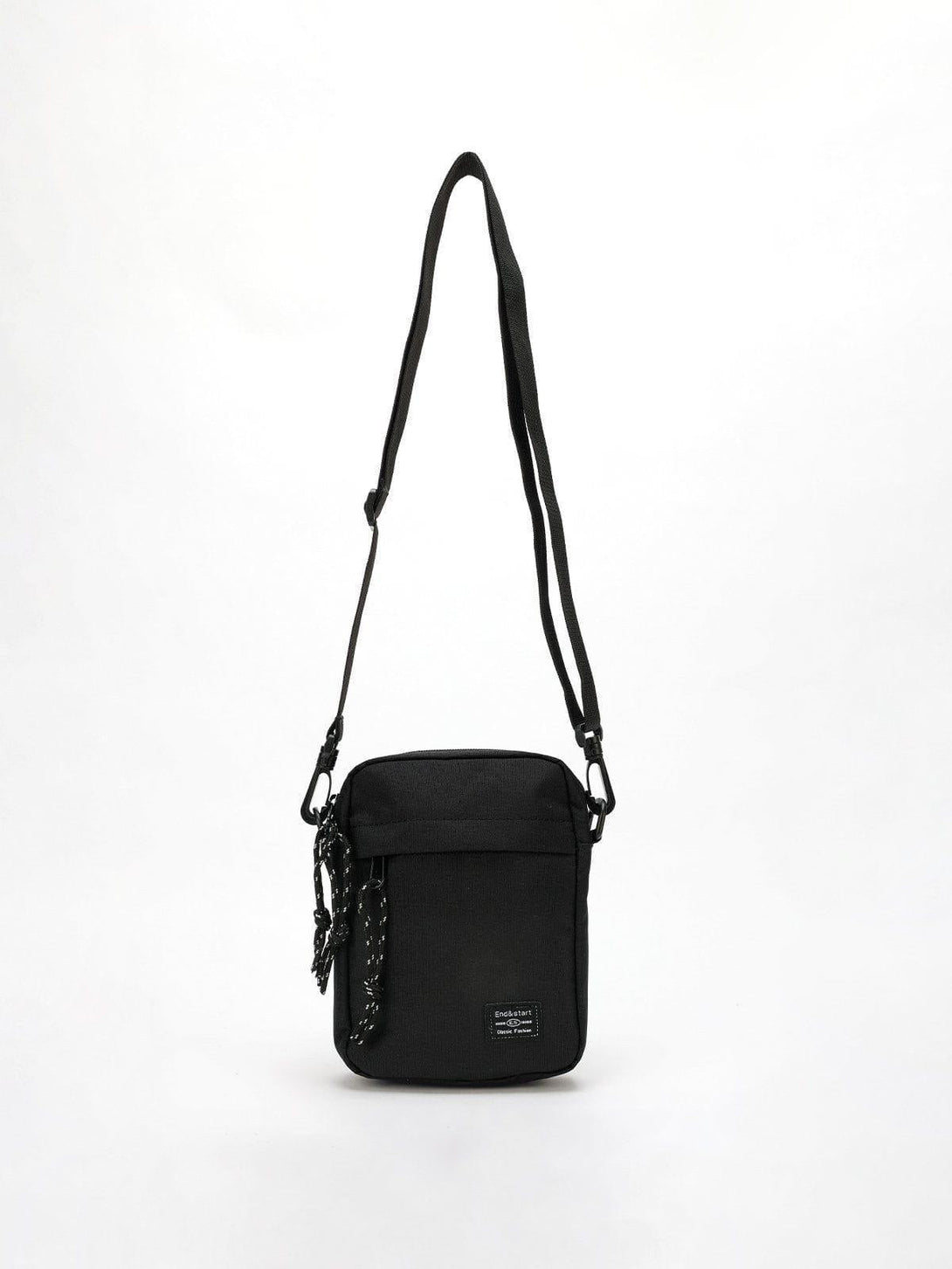 Black square crossbody bag with adjustable strap and front pocket by TALISHKO.
