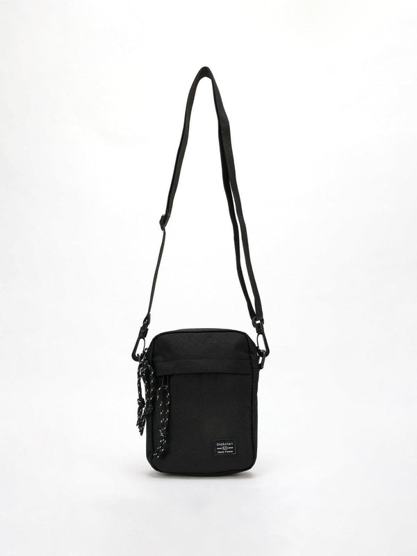 Black square crossbody bag with adjustable strap and front pocket by TALISHKO.