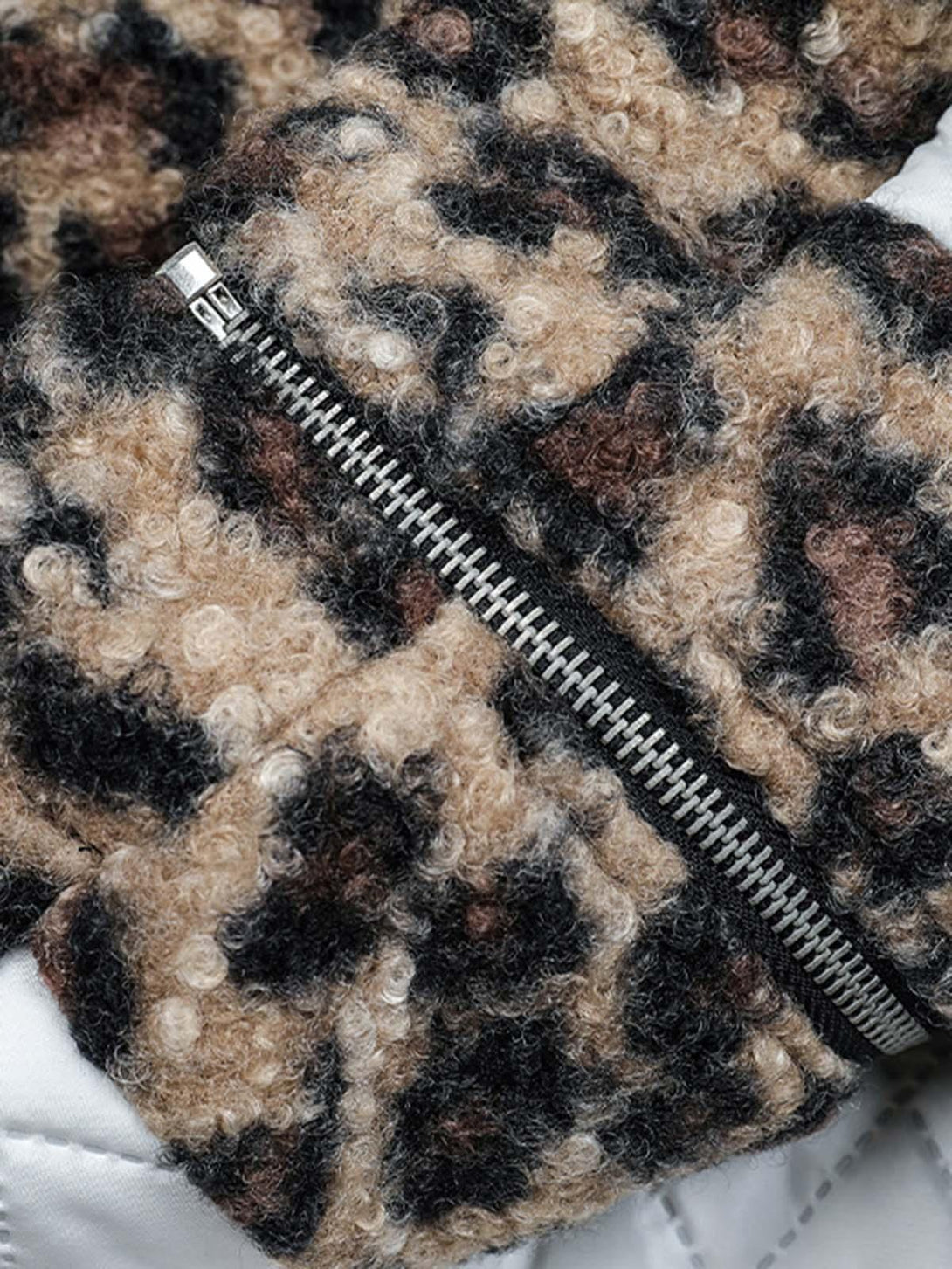 A detailed view of TALISHKO's cheetah print fleece jacket highlighting its textured fabric.
