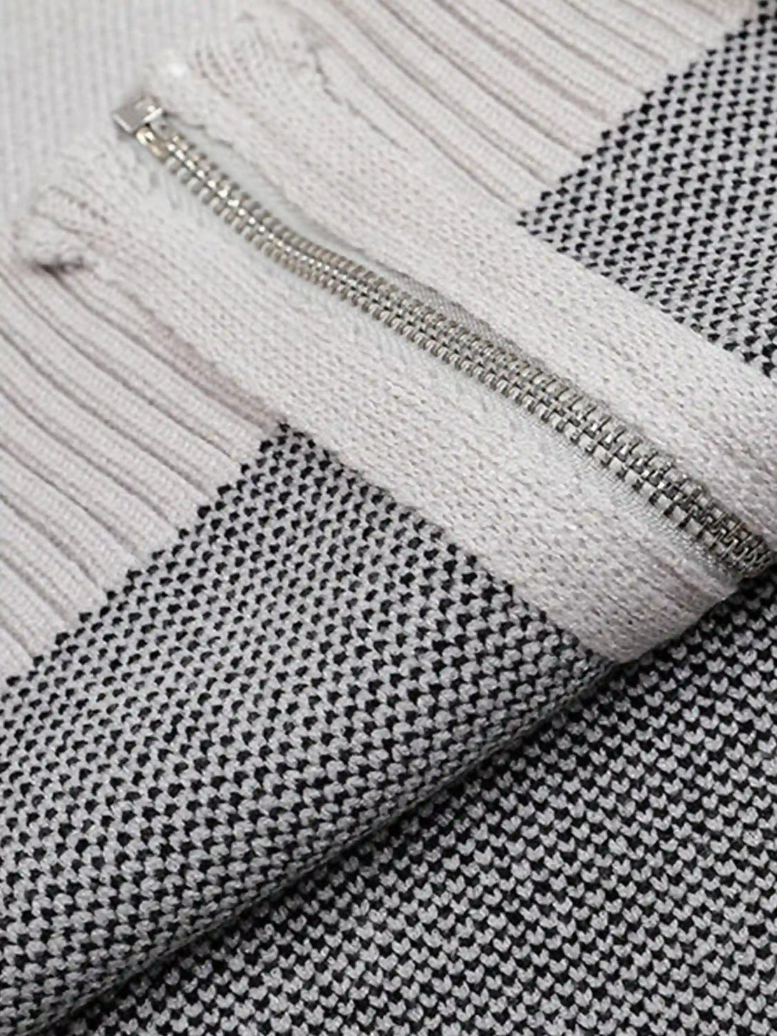 A tight crop highlighting the textured knit and zipper detail of a TALISHKO cardigan.
