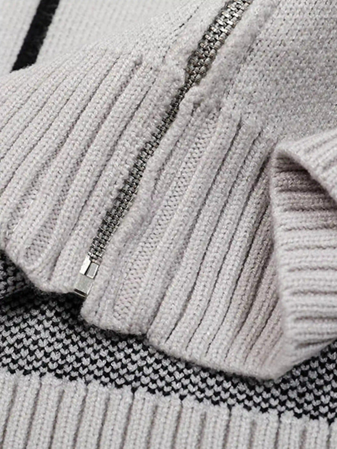 Focusing on the ribbed texture and zipper detail of a TALISHKO cardigan for stylish comfort.