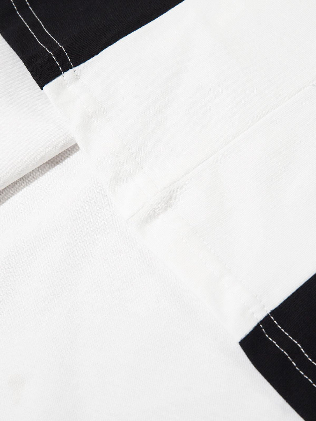 Detailed fabric and stitching on TALISHKO's color-blocked long sleeve shirt.
