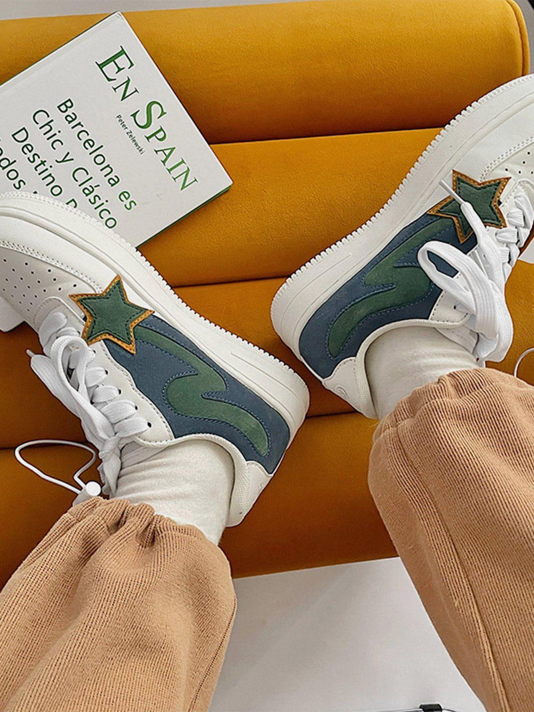 TALISHKO casual shoes with green star design, styled with cozy beige joggers on a yellow seat.