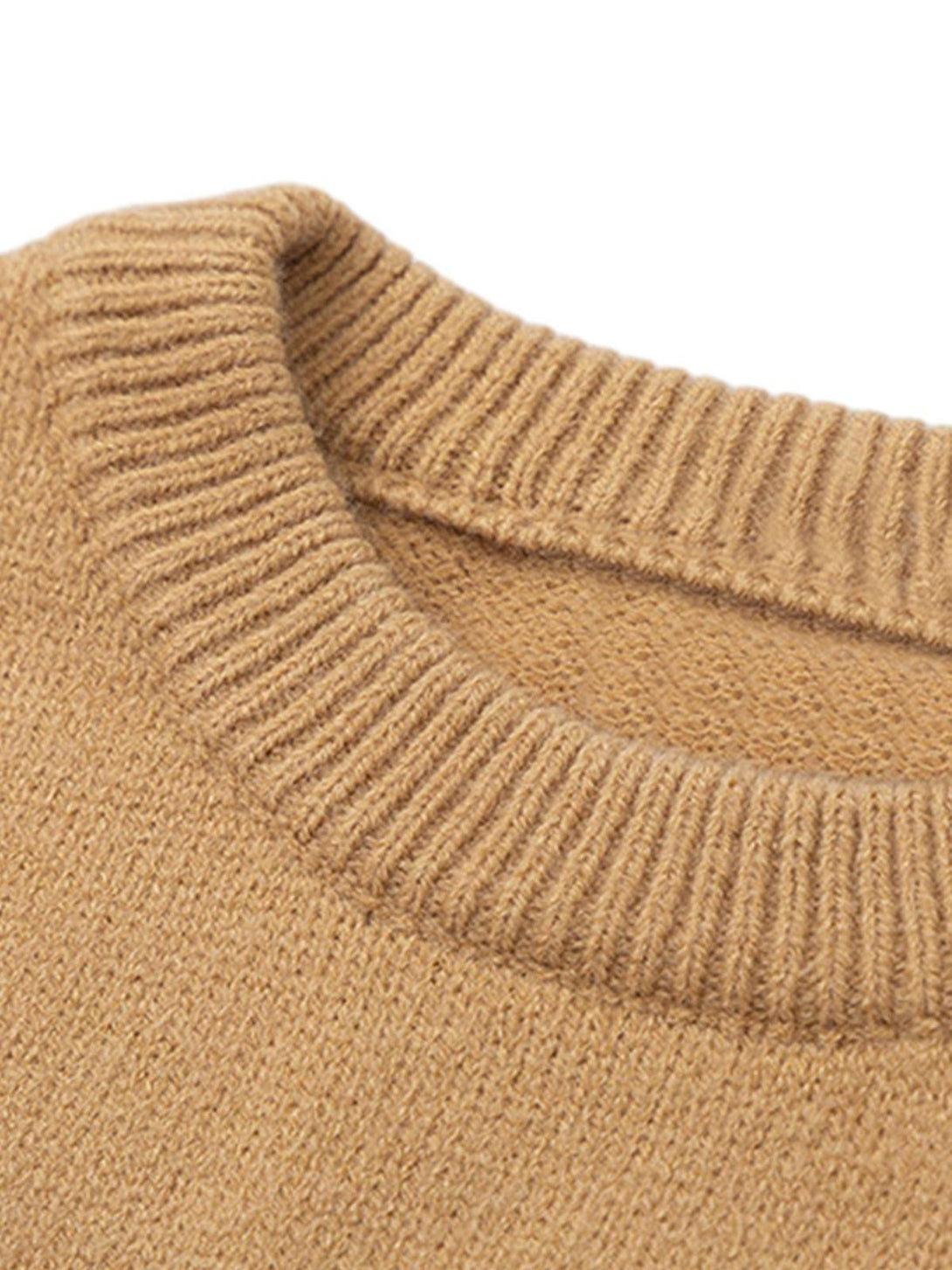 A close-up of the ribbed neckline on a camel knit sweater by TALISHKO.