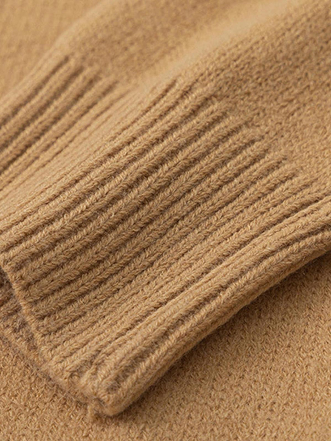 Detailed fabric and ribbed texture of a beige knit sweater by TALISHKO.