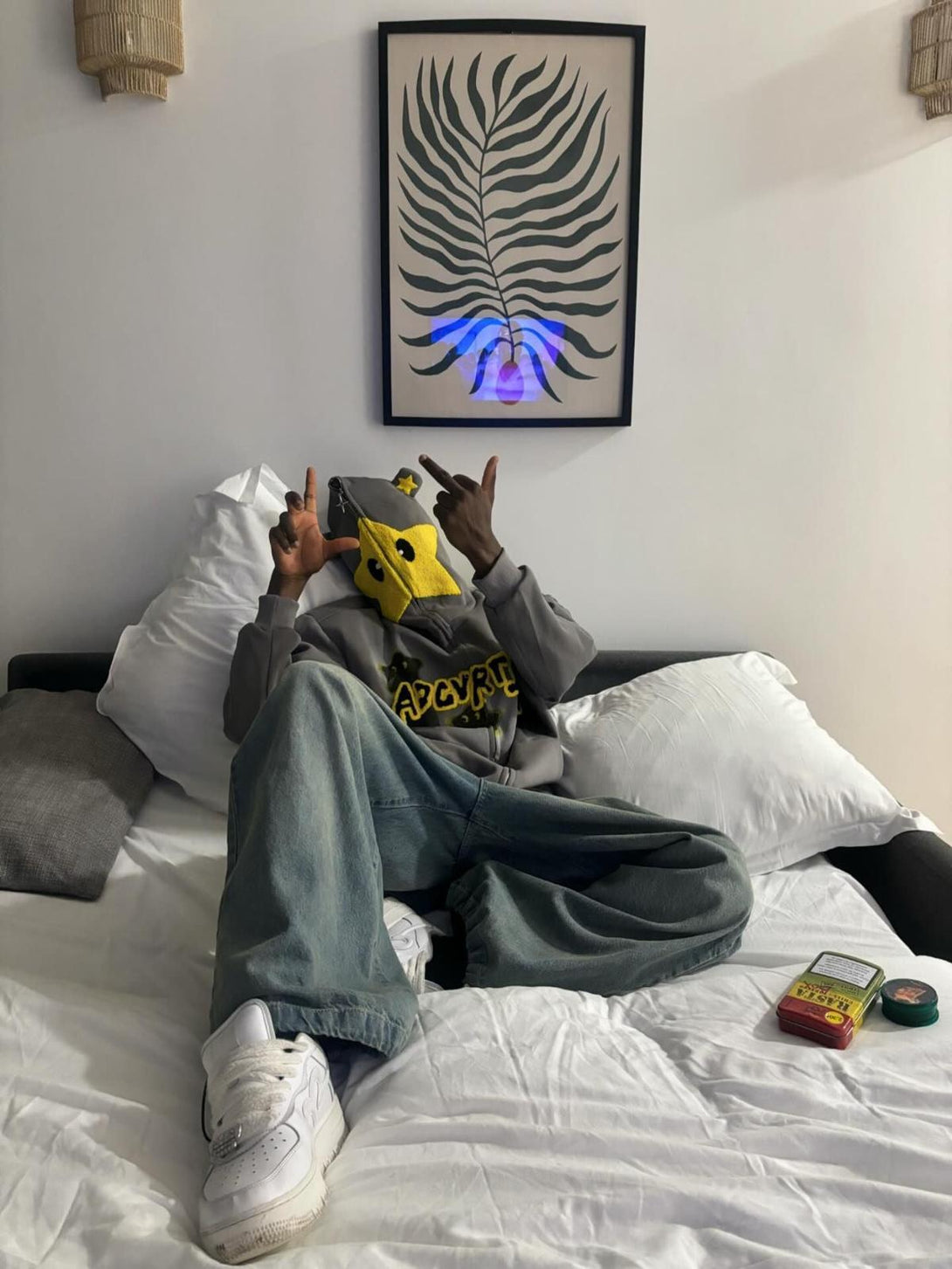 Person lounging in TALISHKO star-embroidered hoodie, showcasing a casual and playful style.