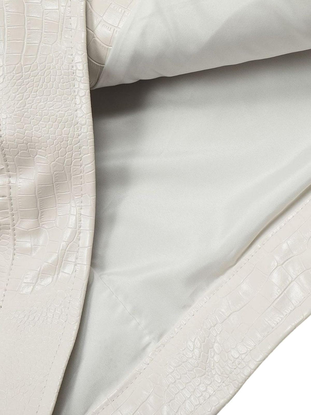 Textured pattern detail of TALISHKO PU leather jacket, showcasing luxurious design elements.
