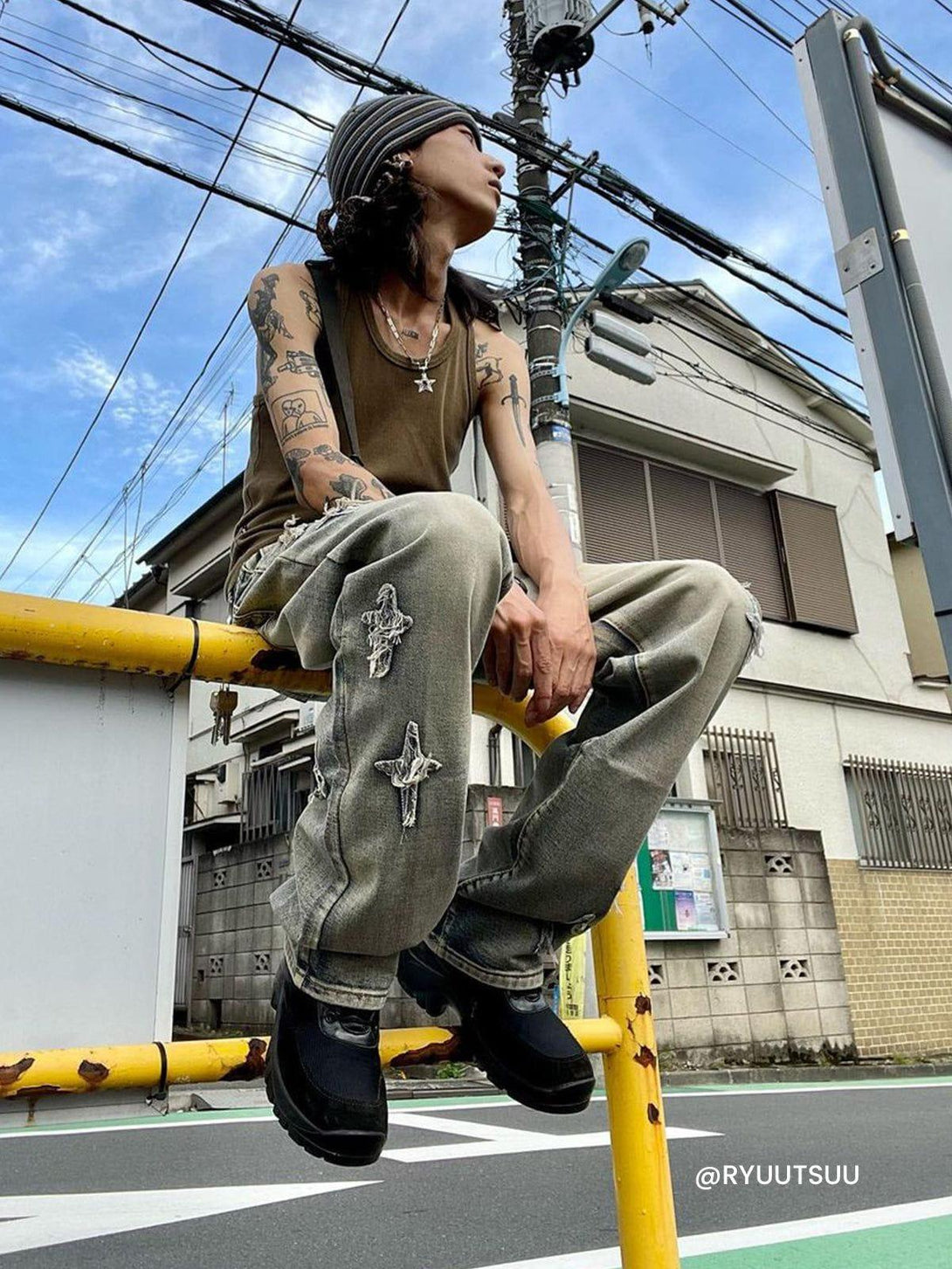 Model wearing TALISHKO star embroidered washed jeans, showcasing urban street fashion.