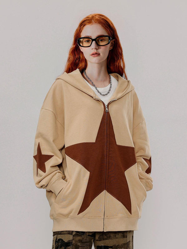Model wearing a tan star graphic print hoodie by TALISHKO, paired with camo pants.