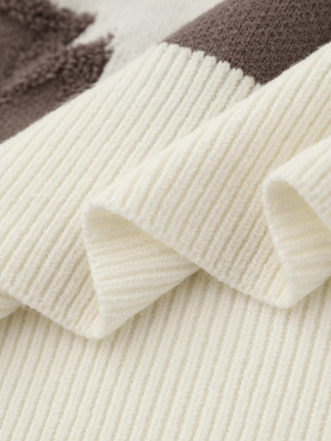 Zoomed-in texture of TALISHKO's star jacquard sweater in cream, highlighting ribbed detail.
