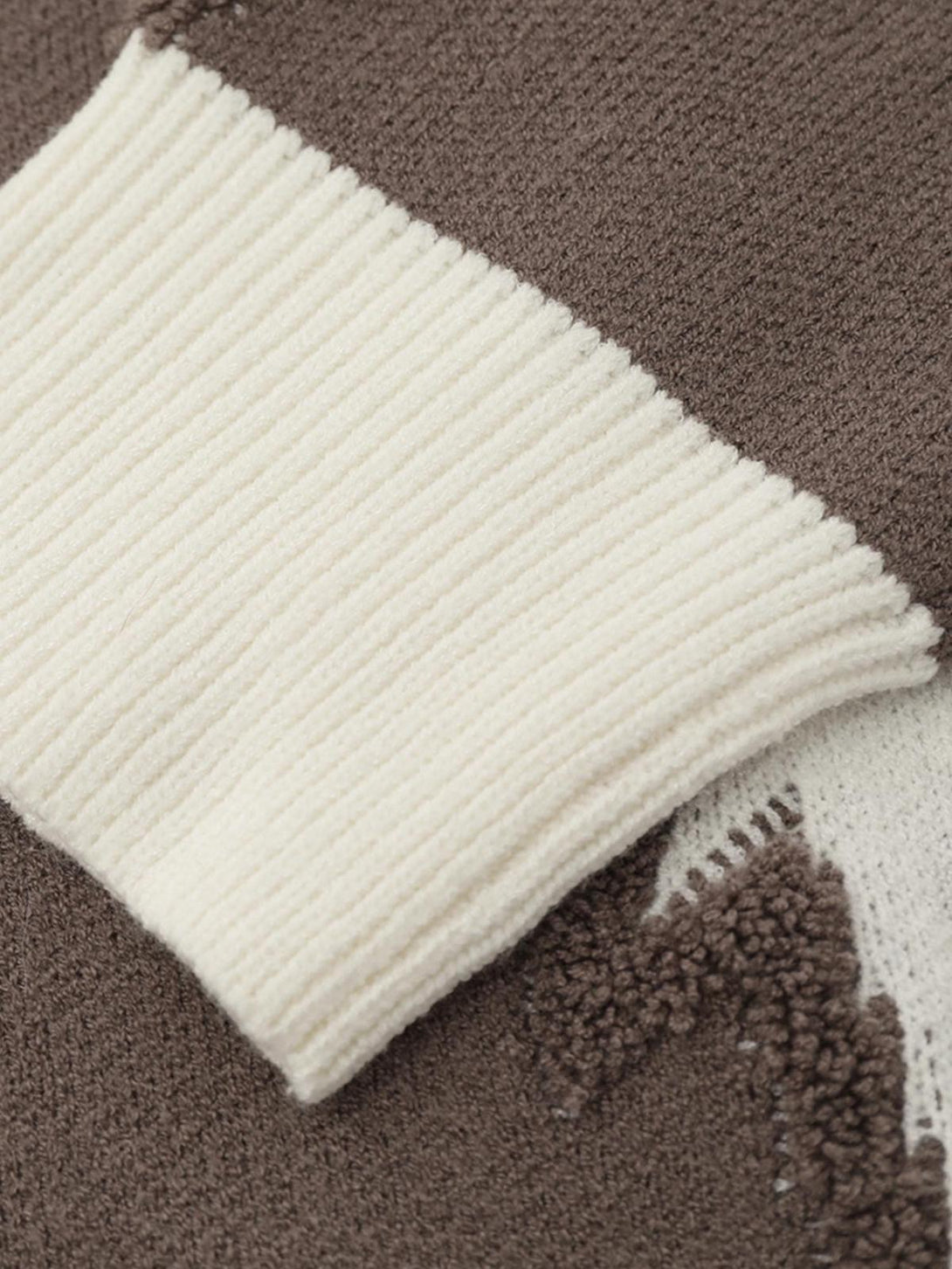 Detailed fabric and texture of TALISHKO's star jacquard crew neck sweater in brown and cream.
