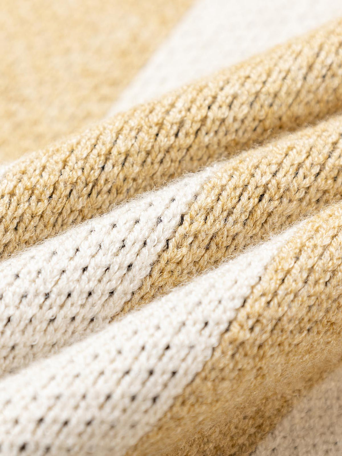 Intricate knit texture of a striped sweater by TALISHKO, highlighting cozy fabric details.