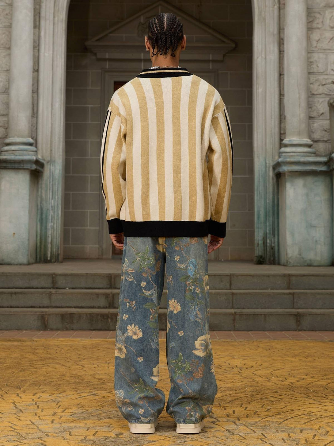 Back view of a striped sweater by TALISHKO, paired with floral denim pants.