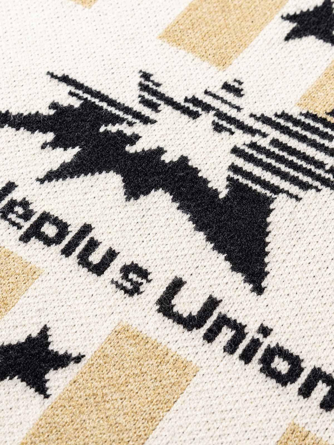 Detailed fabric and stitching of a TALISHKO sweater, showcasing bold star patterns and stripes.