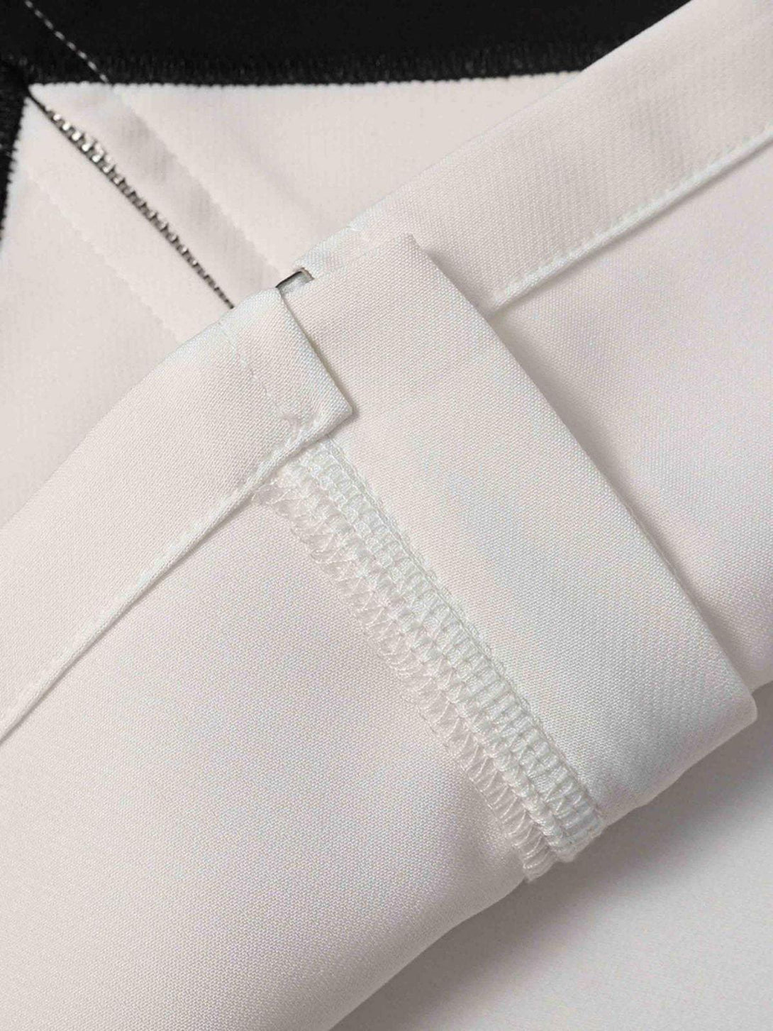 Focusing on TALISHKO's white fabric and stitching detail, showcasing quality craftsmanship.