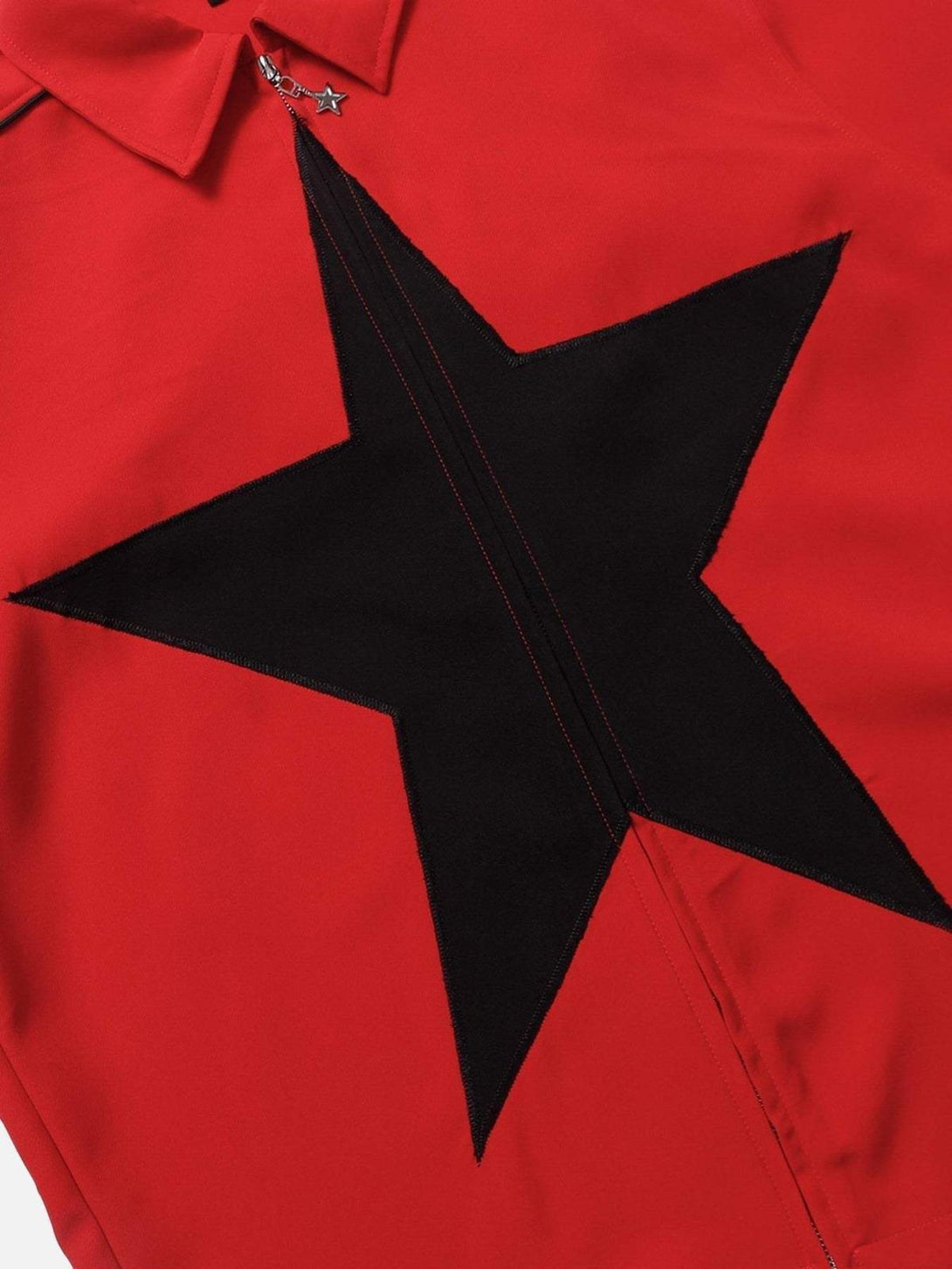 A detailed view of TALISHKO's red shirt with a bold black star and zipper embellishment.