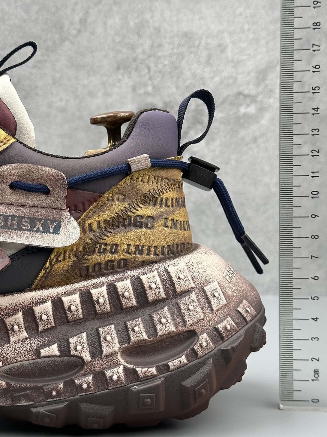 TALISHKO sneakers with distinctive tire soles and detailed stitching, showcasing unique lettering.