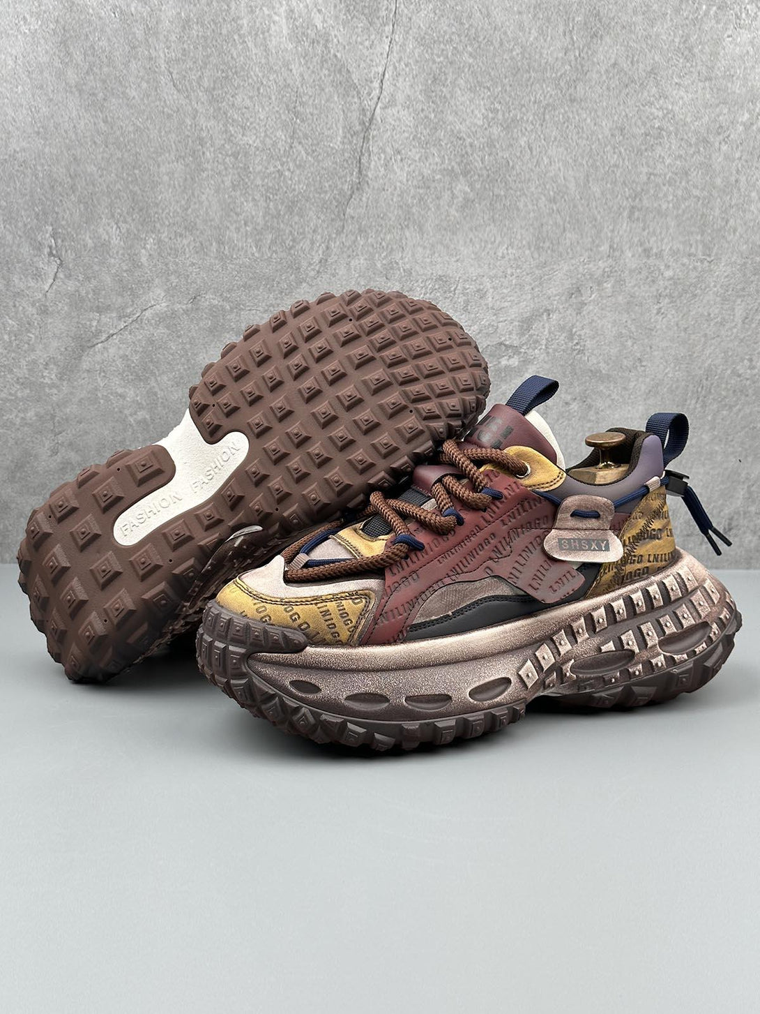 A stylish pair of TALISHKO platform sneakers with unique tire soles and intricate stitching details.