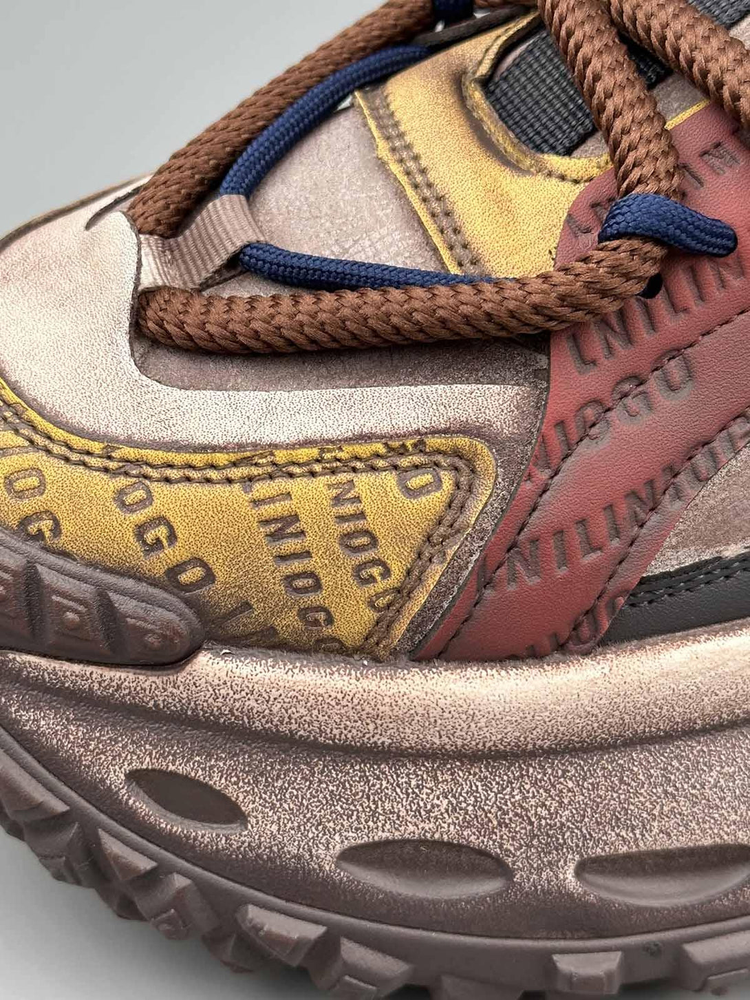 Intricate look at TALISHKO platform sneakers' stitching and lettering on tire sole design.