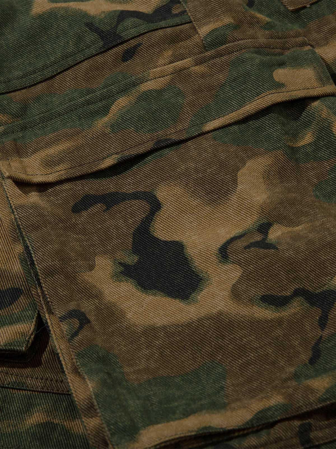 Zoomed-in texture of TALISHKO camouflage cargo pants, highlighting fabric and pocket detail.