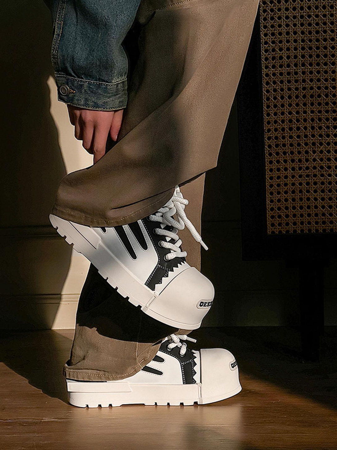 TALISHKO contrast sneakers with a chunky sole, paired stylishly with brown pants and denim.