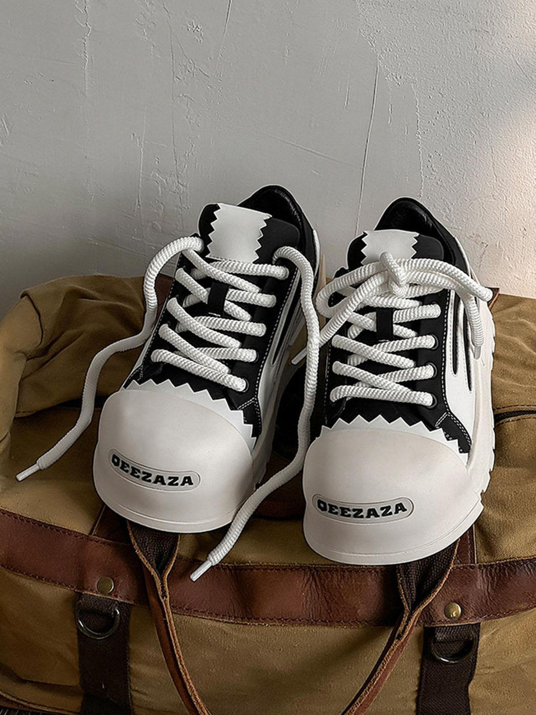 TALISHKO casual sneakers with bold contrast accents and unique detailing on a rustic bag.