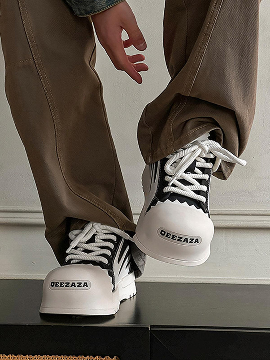 TALISHKO sneakers with unique contrast design, paired with casual brown pants for street style.