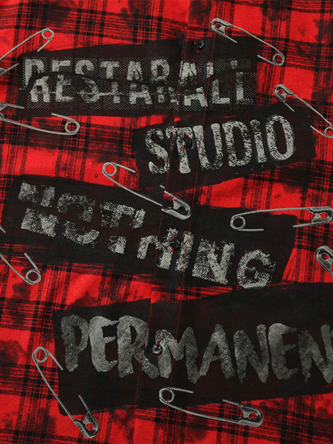 Intricate look at the red plaid shirt's graphic text and safety pin detailing by TALISHKO.