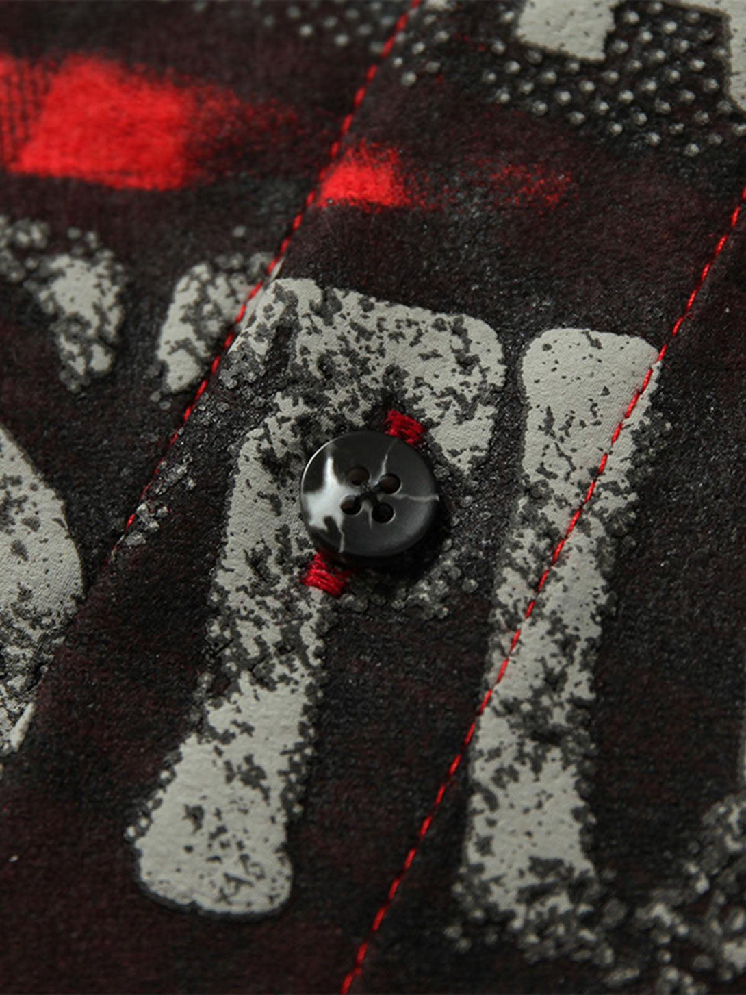 Detailed fabric and stitching of a TALISHKO plaid shirt, highlighting graphic text and button detail.