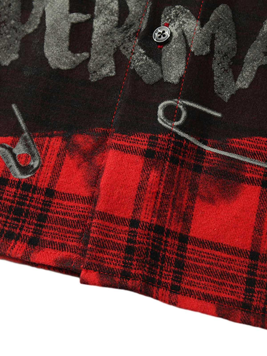 Close-up of TALISHKO's plaid shirt, highlighting graphic text and safety pin details.
