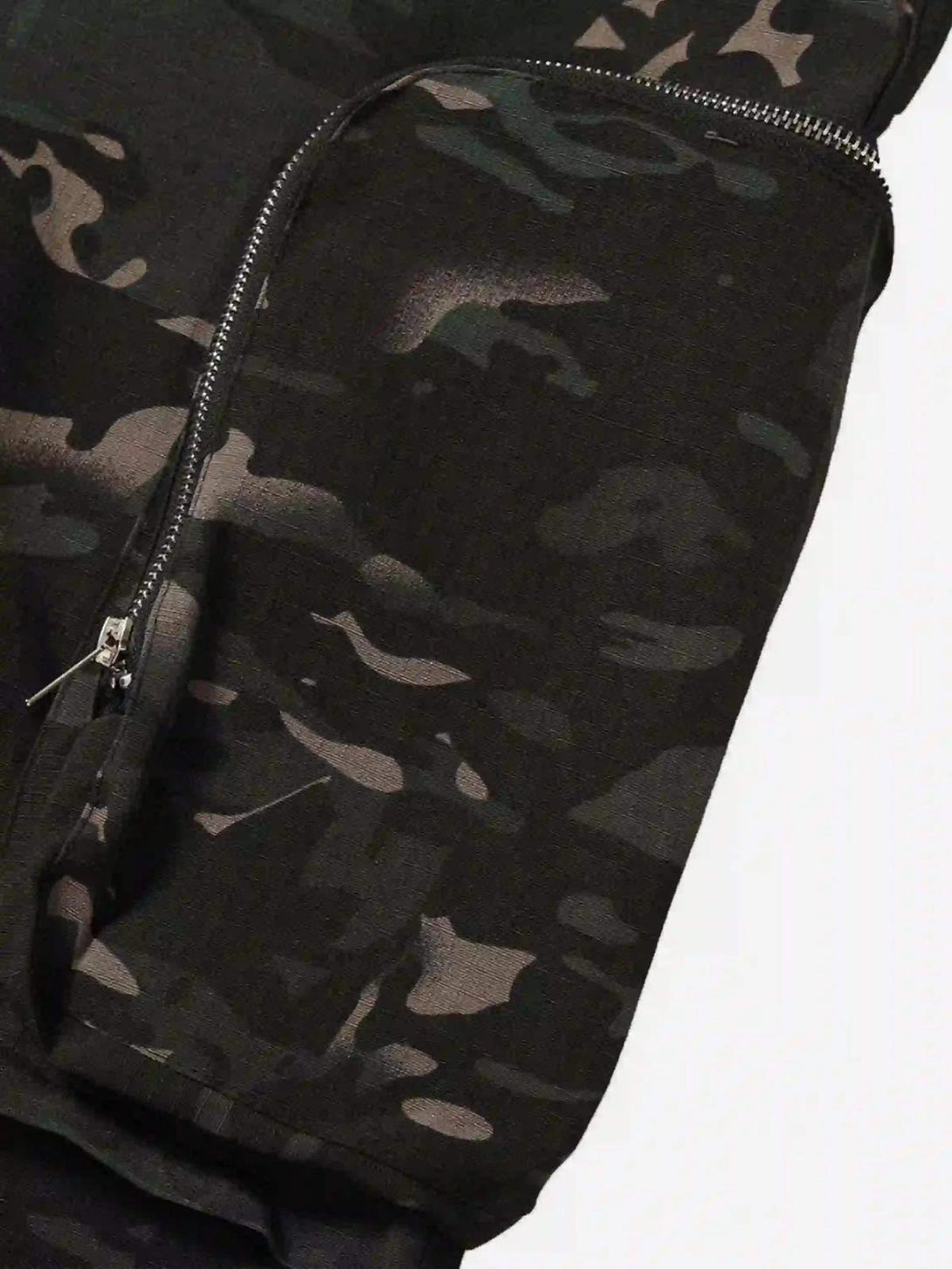 A detailed view of TALISHKO cargo pants showcasing dark camouflage pattern and zipper design.