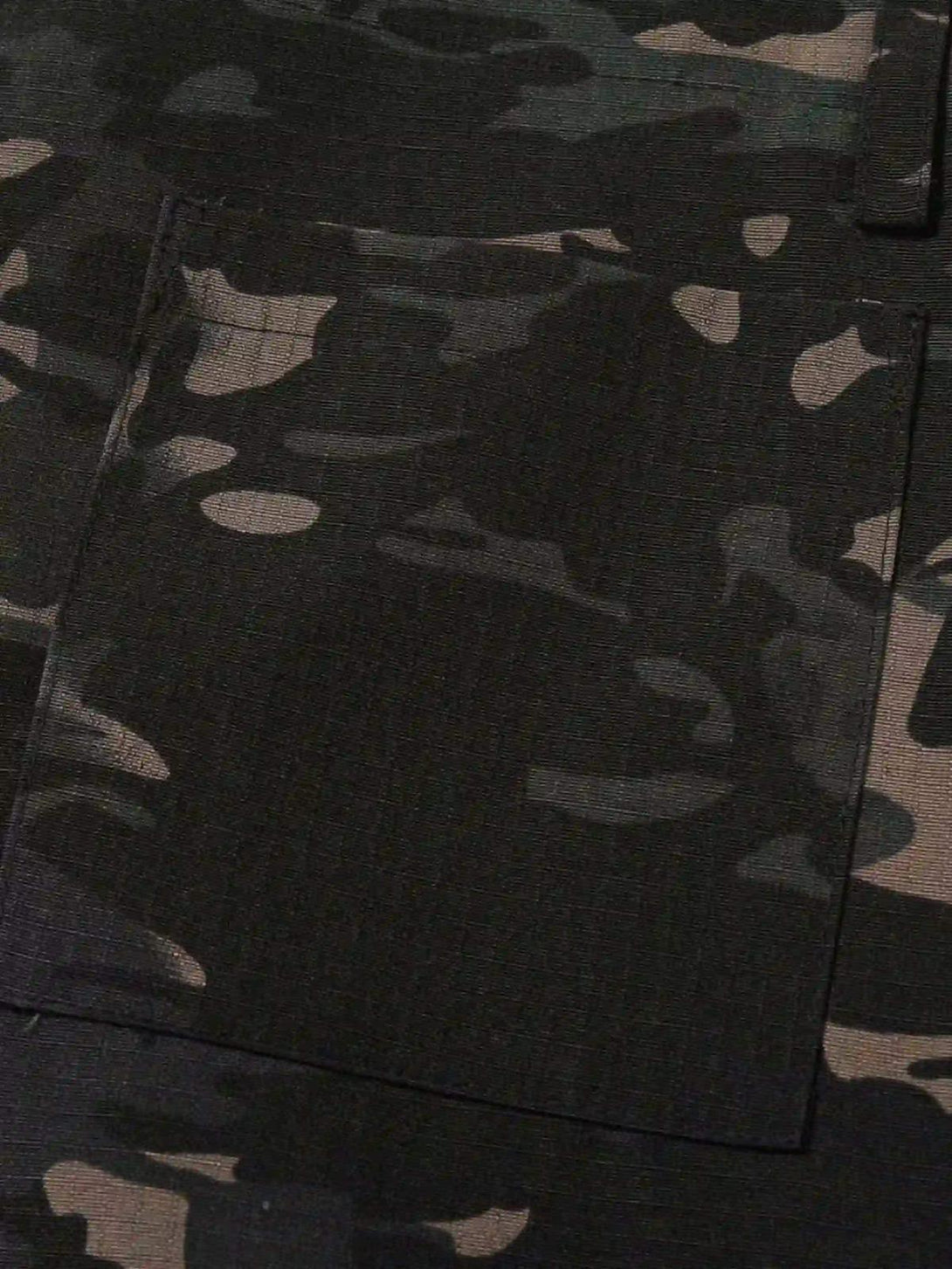 Texture and pattern showcased on TALISHKO's dark camouflage cargo pants, highlighting rugged style.