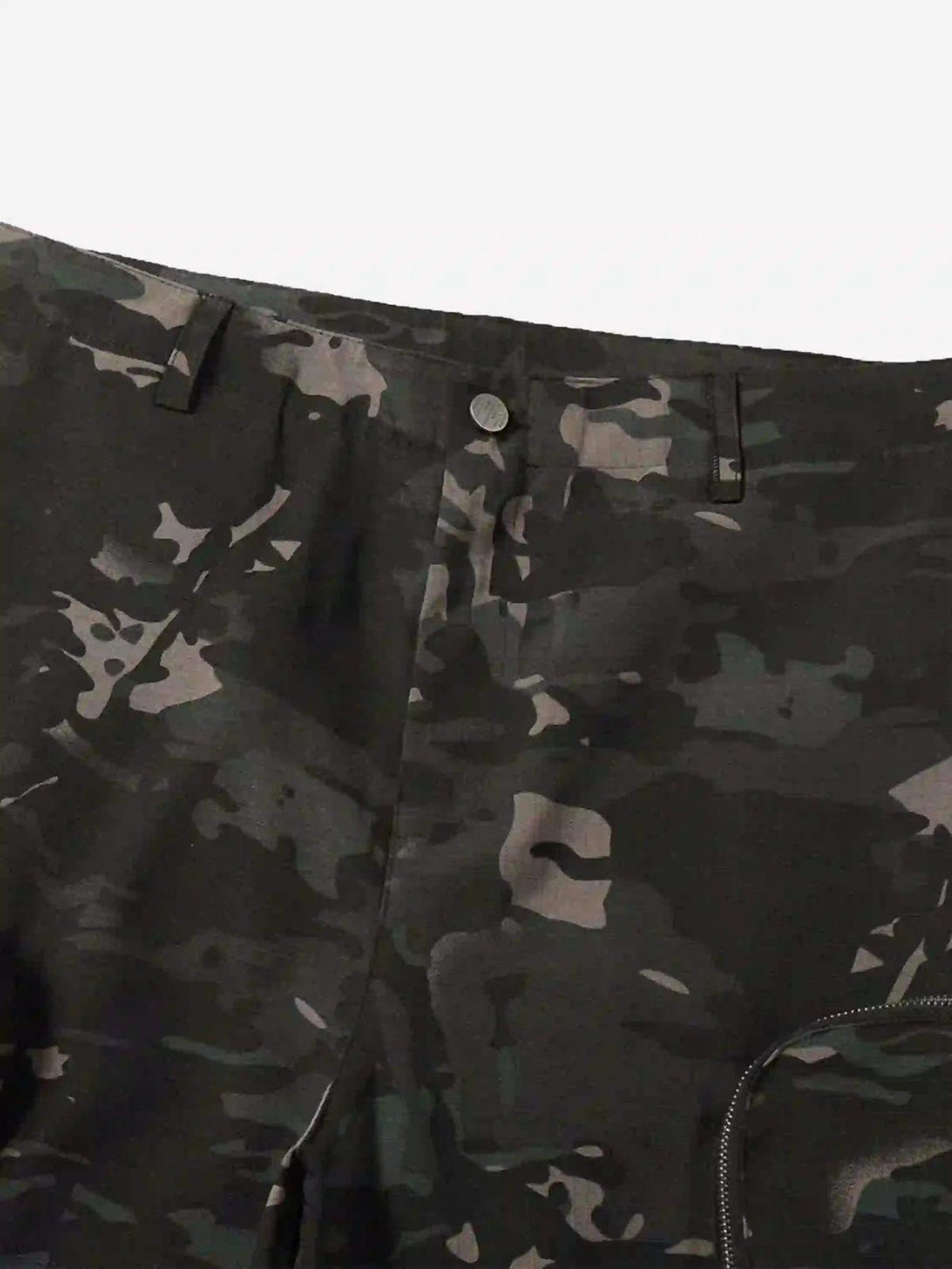 A detailed view of TALISHKO dark camouflage cargo pants highlighting the zipper and pattern.