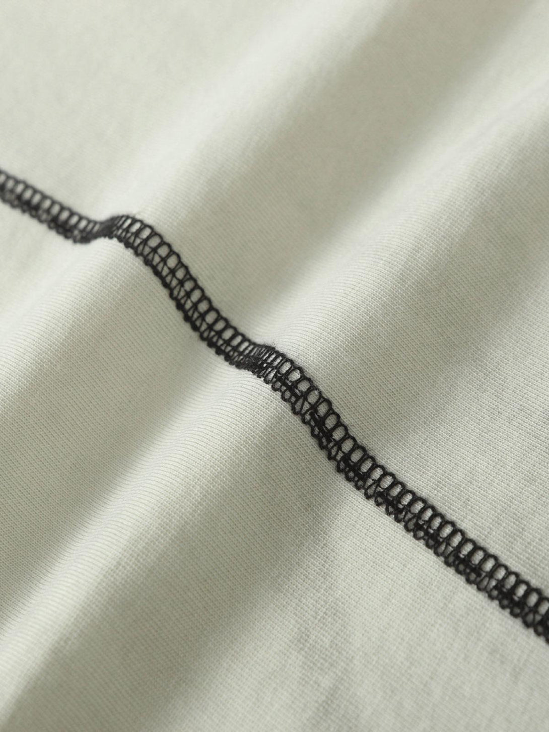 Intricate look at TALISHKO T-shirt's stitching detail, highlighting its unique craftsmanship.