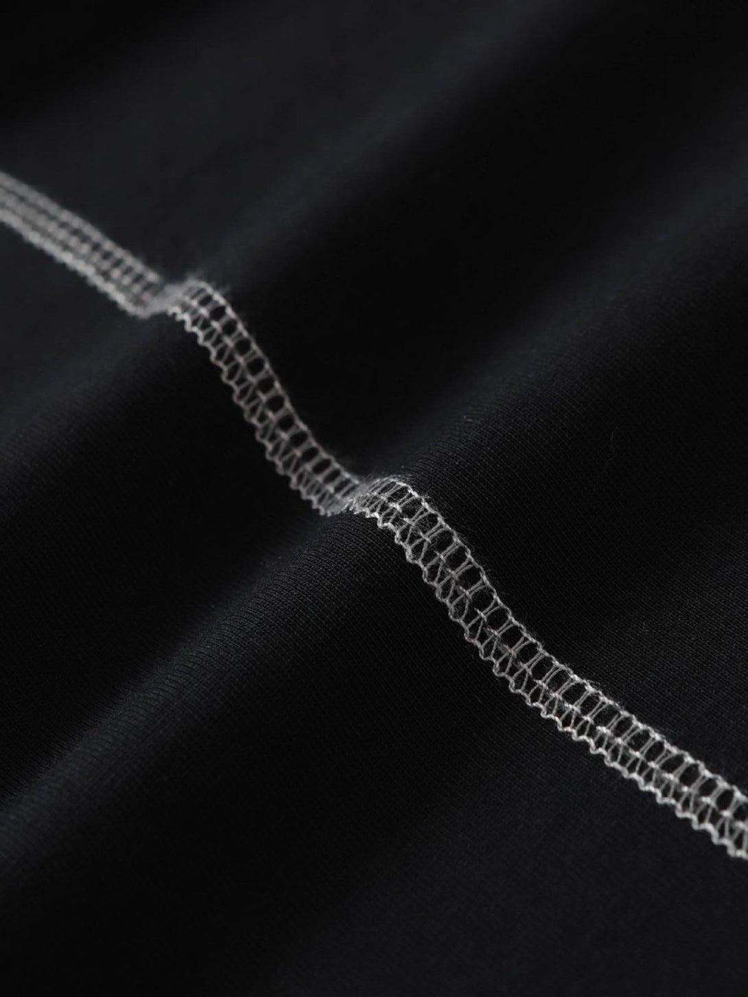 Detailed stitching and fabric texture of a TALISHKO motorcycle T-shirt in a dark hue.