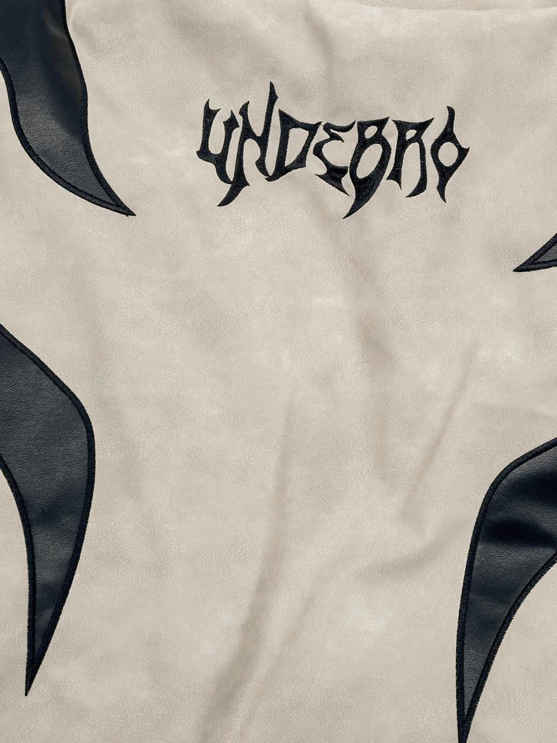 Zoomed-in view of TALISHKO's suede puffer jacket showcasing unique flame embroidery detail.