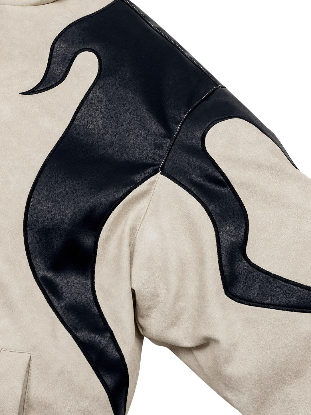 A tight crop highlighting the flame embroidery on TALISHKO's suede puffer jacket.
